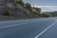 the car is driving along the freeway on a sunny day in the countryside with trees