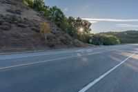 the car is driving along the freeway on a sunny day in the countryside with trees