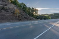 the car is driving along the freeway on a sunny day in the countryside with trees