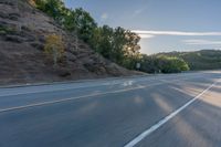 the car is driving along the freeway on a sunny day in the countryside with trees