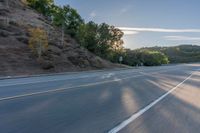 the car is driving along the freeway on a sunny day in the countryside with trees