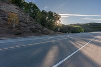 the car is driving along the freeway on a sunny day in the countryside with trees