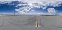 an empty parking lot with a few white clouds overhead and many blue sky above the rest