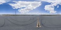 two white cars driving down the middle of an empty road in the desert of california