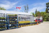 a truck is sitting in front of some flower stand and display cases on crates under blue tarp