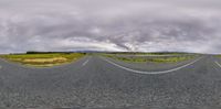 a panoramic image taken from an empty road and showing several lanes of the same width