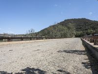 a view from a bridge overlooking trees and a mountain range of hills behind a bridge