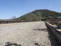 a view from a bridge overlooking trees and a mountain range of hills behind a bridge