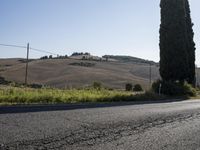 a motorcycle parked on the side of the road in front of some hills and a blue sky