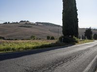 a motorcycle parked on the side of the road in front of some hills and a blue sky