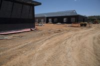 Rural Road with Wooden House Under Clear Sky
