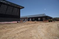 Rural Road with Wooden House Under Clear Sky