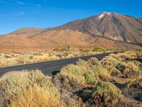 the road is paved in two sections with mountains in the distance and scrub vegetation around it