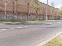 an empty street with grass and buildings near by in a rural town area, on a clear blue day