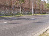 an empty street with grass and buildings near by in a rural town area, on a clear blue day