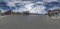 a 360 - panoramic view of an empty street with buildings and shops across the street