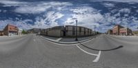 the image of a street and a sky from a fisheye lens with buildings on both sides