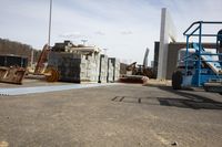 several crates are laid out on a flat surface with crane mounted equipment in the background