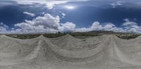 multiple panoramic photographs show a half pipe going through dirt circles, with a sky and clouds above