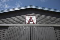 an aa sign sitting on the roof of a barn, with the letter'aa'above it