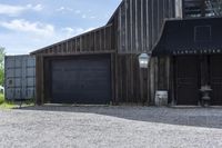 a barn next to a building with two doors and a bicycle leaning against it's wall