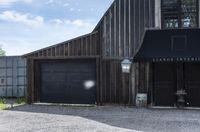 a barn next to a building with two doors and a bicycle leaning against it's wall