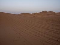 an image of the desert at dusk or sunrise, the horizon view with only one person on the right side