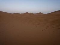 an image of the desert at dusk or sunrise, the horizon view with only one person on the right side