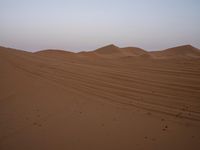 an image of the desert at dusk or sunrise, the horizon view with only one person on the right side