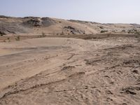 a truck on a dirt road in the desert with rocks and stones on the ground