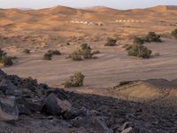 a truck on a dirt road in the desert with rocks and stones on the ground