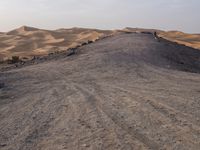 a truck on a dirt road in the desert with rocks and stones on the ground