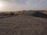 a truck on a dirt road in the desert with rocks and stones on the ground