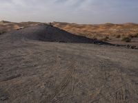 a truck on a dirt road in the desert with rocks and stones on the ground