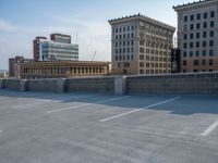 several large empty parking spaces in the city with buildings nearby in front of them -