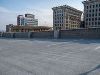 several large empty parking spaces in the city with buildings nearby in front of them -