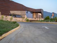 a building that has a bunch of windows on it at sunset with mountains in the background