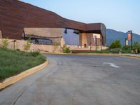 a building that has a bunch of windows on it at sunset with mountains in the background