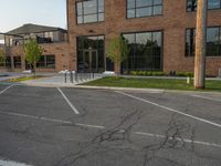 an empty street in front of a large red brick building on the other side of the road is a street light that has a line for motorists