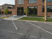 an empty street in front of a large red brick building on the other side of the road is a street light that has a line for motorists