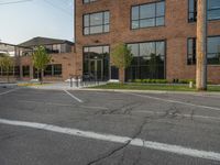 an empty street in front of a large red brick building on the other side of the road is a street light that has a line for motorists