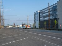 an empty street in front of a large red brick building on the other side of the road is a street light that has a line for motorists