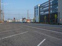 an empty street in front of a large red brick building on the other side of the road is a street light that has a line for motorists