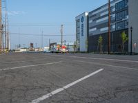 an empty street in front of a large red brick building on the other side of the road is a street light that has a line for motorists