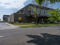 a building with a logo painted on the side near a street that has a sidewalk next to it