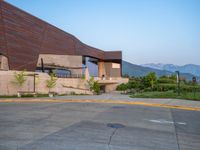 a building that has a bunch of windows on it at sunset with mountains in the background