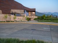 a building that has a bunch of windows on it at sunset with mountains in the background