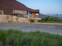 a building that has a bunch of windows on it at sunset with mountains in the background