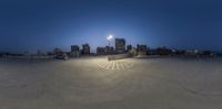 a view of a city at night in the distance, with a skateboarder about to do the air