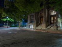 a city street at night with parking meters on either side and the road in the center